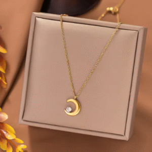 Close-up of a stainless steel moon pendant necklace with zircon on a dainty clavicle chain, minimalist jewelry for women.